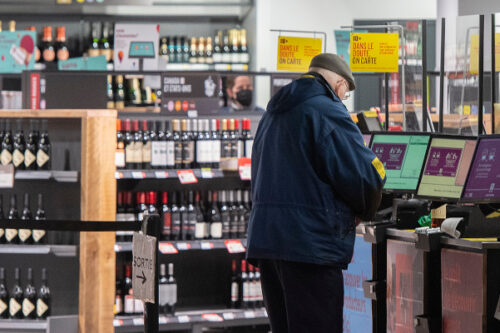 A man purchases alcohol at a SAQ outlet in Montreal, Tuesday, January 18, 2022. Graham Hughes/The Canadian Press.