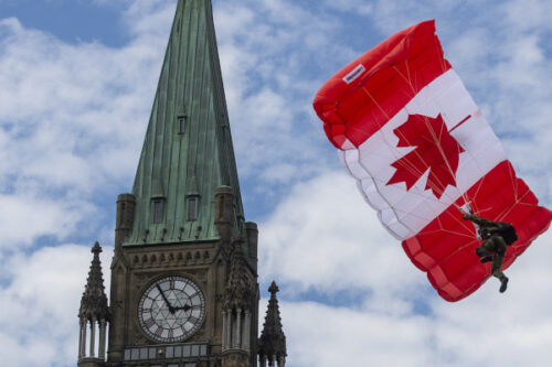 A Skyhawk member glides beside the Peace tower during Canada Day events in Ottawa on July 1, 2022. Lars Hagberg/The Canadian Press.