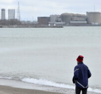 A jogger runs along the beach past the Pickering Nuclear Generating Station, in Pickering on Jan. 12, 2020. Frank Gunn/The Canadian Press.