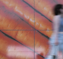 Shoppers walk past a large poster outside a supermarket in London on June 10, 2023. Alastair Grant/AP Photo.