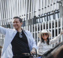 Conservative Party leader Pierre Poilievre rides a horse with his wife Anaida Poilievre during the Calgary Stampede parade in Calgary on July 7, 2023. Jeff McIntosh/The Canadian Press.