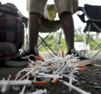 In this Dec. 14, 2018 photo, a drug user turns in his used syringes to volunteers from the "Intercambios Puerto Rico" needle exchange program, in order to get new, clean ones, in an area popular with drug users in Humacao, Puerto Rico. Carlos Giusti/AP Photo. 