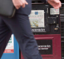 A man walks past newspaper boxes containing the Vancouver Sun and the Province in downtown Vancouver, Tuesday, Jan. 19, 2016. Jonathan Hayward/The Canadian Press. 