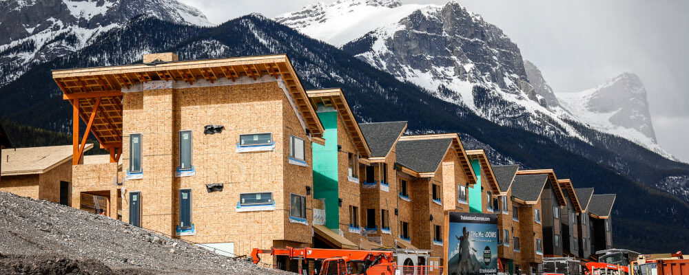 Mountains loom behind homes under construction in Canmore, Alta., Monday, April 24, 2023. Jeff McIntosh/The Canadian Press. 