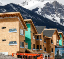 Mountains loom behind homes under construction in Canmore, Alta., Monday, April 24, 2023. Jeff McIntosh/The Canadian Press. 