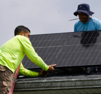 Brian Hoeppner, right, and Nicholas Hartnett, owner of Pure Power Solar, install a solar panel on the roof of a home in Frankfort, Ky., Monday, July 17, 2023. Michael Conroy/AP Photo. 