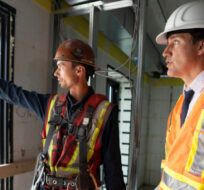 Prime Minister Justin Trudeau speaks with construction worker Patrick Van Dam during a visit to an apartment complex under construction in Hamilton, Ont., Monday, July 31, 2023. Peter Power/The Canadian Press. 