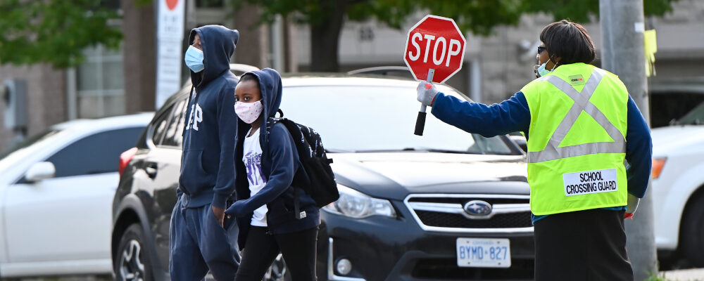 Children cross the street while arriving at Portage Trail Community School which is part of the Toronto District School Board (TDSB) in Toronto on Tuesday, September 15, 2020. Nathan Denette/The Canadian Press. 
