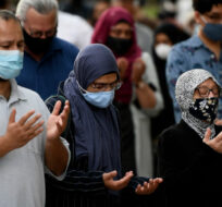 People raise their hands in prayer at a vigil for  the four family members who were killed in a vehicle attack that police say was motivated by anti-Muslim hate, in London, Ont., in Ottawa, on Tuesday, June 8, 2021. Justin Tang/The Canadian Press. 