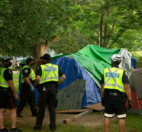 Police and city officials circle tents as they work to clear the Alexandra Park encampment  in Toronto, on Tuesday, July 20, 2021. Chris Young/The Canadian Press. 