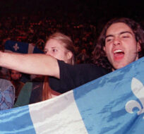A Yes supporter holding a Quebec flag chants nationalist slogans prior to a concert of Quebec rock stars in support of sovereignty in Montreal Friday Sept. 29, 1995. Paul Chiasson/The Canadian Press. 