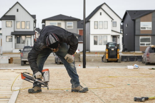 Framers work on a new house under construction in Airdrie, Alberta on Jan. 28, 2022. Jeff McIntosh/The Canadian Press.