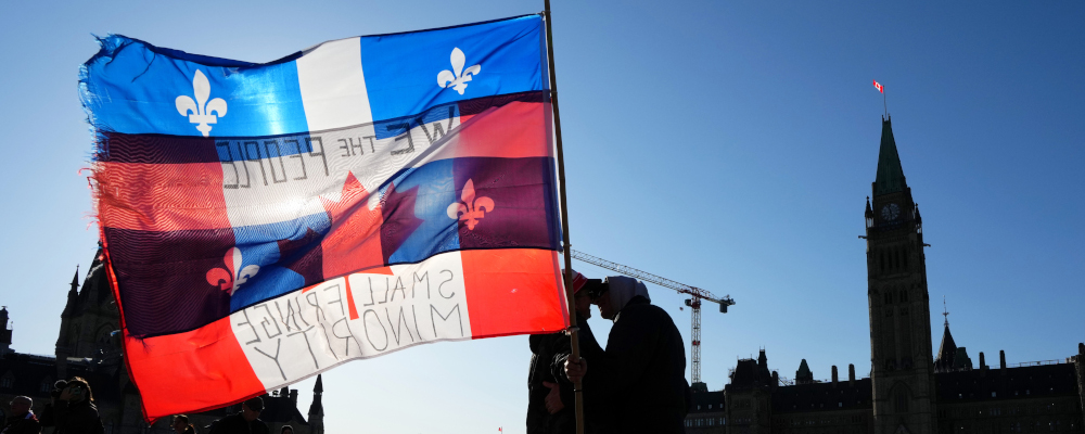 Protesters embrace while holding Canadian and Quebec flags in Ottawa, Friday, April 29, 2022. Sean Kilpatrick/The Canadian Press. 