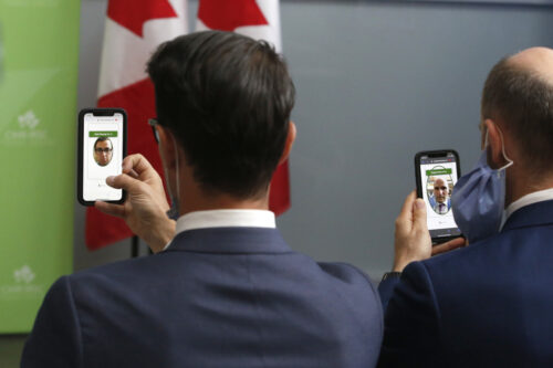 Liberal MP Adam van Koeverden, left, and Health Minister Jean-Yves Duclos use an app on their phones to vote virtually in the House of Commons on June 22, 2022. Patrick Doyle/The Canadian Press.
