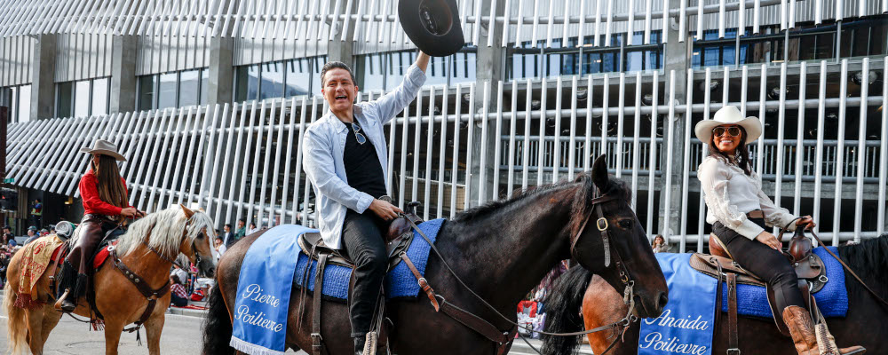 Conservative Party leader Pierre Poilievre, centre, rides a horse with his wife Anaida Poilievre during the Calgary Stampede parade in Calgary, Friday, July 7, 2023. Jeff McIntosh/The Canadian Press. 