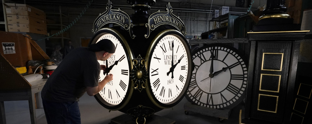 Dan LaMoore adjusts the hands on a Seth Thomas Post Clock at Electric Time Company in Medfield, Mass. Elise Amendola/AP Photo.