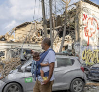Israelis inspect the rubble of a building a day after it was hit by a rocket fired from the Gaza Strip, in Tel Aviv, Israel on Oct. 8, 2023. Oded Balilty/AP Photo.