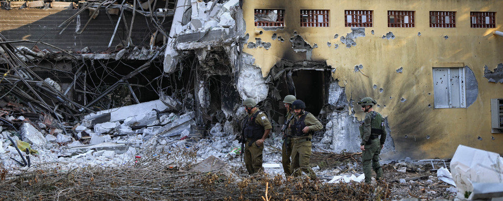 Israeli soldiers walk past houses destroyed by Hamas militants in Kibbutz Be'eri, Israel on Oct. 14, 2023. Ariel Schalit/AP Photo.