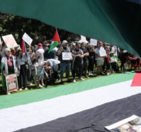 A large Palestinian flag is laid out as people gather in central Sydney for a rally on Oct. 15, 2023 to support Palestinians in Gaza. Rick Rycroft/AP Photo.