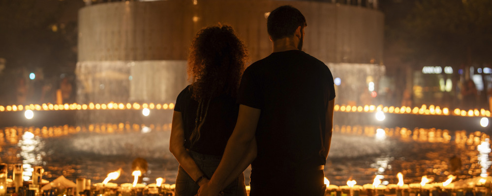 A young couple stand in front of lighted candles in honour of victims of the Hamas attacks during a vigil at the Dizengoff square in central Tel Aviv, Israel, on Oct 18, 2023. Petros Giannakouris/AP Photo.