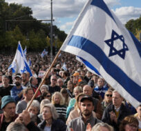 People waves Israeli flags during a demonstration against antisemitism and to show solidarity with Israel in Berlin, Germany, Sunday, Oct. 22, 2023. Markus Schreiber/AP Photo. 