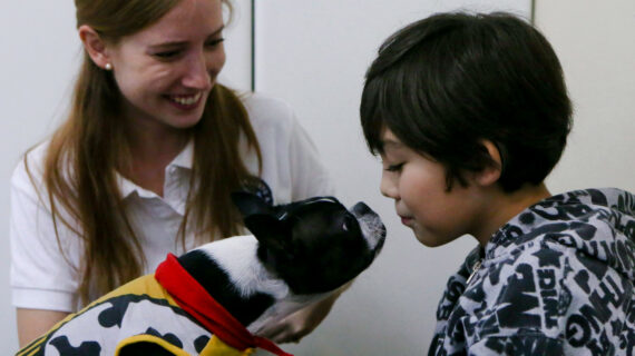 In this April 28, 2017 photo, 9-year-old Diego Rosales, who has autism, interacts with therapy dog Perry before his dental appointment at the Los Andes University Medical Center on the outskirts of Santiago, Chile. Esteban Felix/AP Photo. 