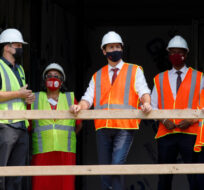 Canada's Prime Minister Justin Trudeau, centre, tours an under construction affordable housing complex in Hamilton, Ont., Tuesday, July 20, 2021. Cole Burston/The Canadian Press. 
