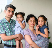 Hamid Ahmadpanah, left, and Shohreh Aghababaei, second from right, stand with their daughters Kyla, 15 months, and Amelia, 5, at their home in Ottawa, on Thursday, June 8, 2023. Justin Tang/The Canadian Press. 