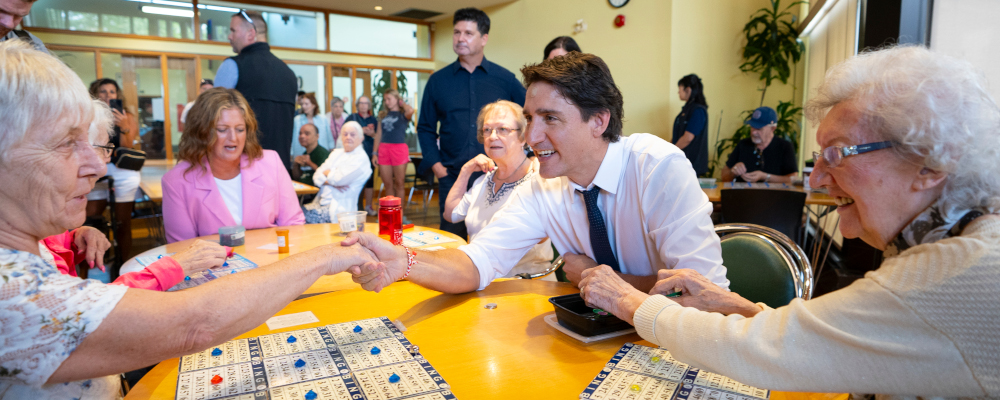 Prime Minister Justin Trudeau sits with a group of seniors between Bingo games during a visit to Sackville Hill Senior Recreation Centre in Hamilton, Ont., Monday, July 31, 2023. Peter Power/The Canadian Press. 