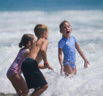 Children play as waves roll onto the beach Saturday, Aug. 5, 2023, in Huntington Beach, Calif. Ryan Sun/AP Photo. 