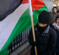 Two Northeastern University students carry a Palestinian flag during a protest in support of Palestine in Boston, Tuesday, March 18, 2014. Stephan Savoia/AP Photo. 