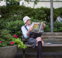 John Kelly reads a newspaper while sitting on a park bench in downtown Vancouver, on Wednesday July 25, 2018. Darryl Dyck/The Canadian Press. 