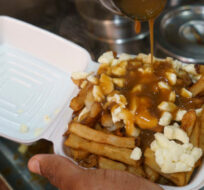 A cook prepares a poutine in Montreal on Tuesday, May 18, 2021. Paul Chiasson/The Canadian Press. 