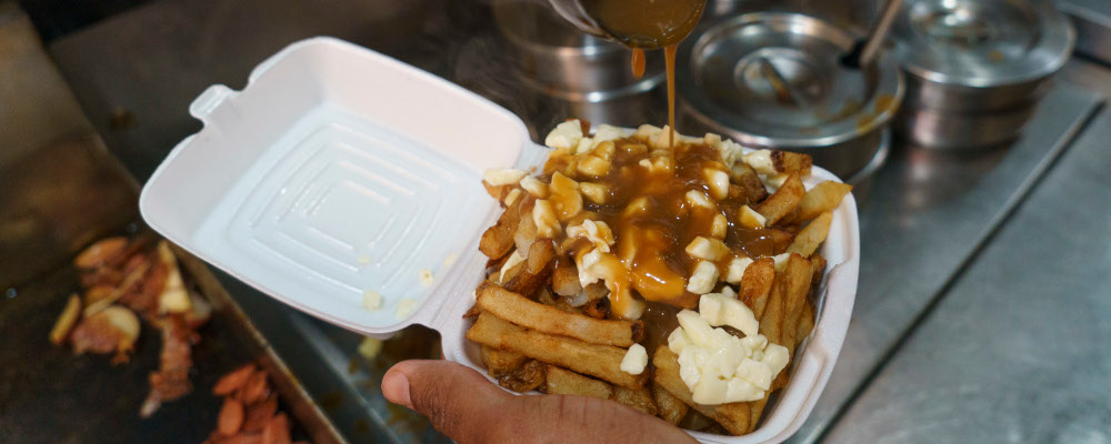 A cook prepares a poutine in Montreal on Tuesday, May 18, 2021. Paul Chiasson/The Canadian Press. 