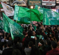 Palestinians wave Hamas flags as they celebrate the Israeli release of Palestinian prisoners in the West Bank city of Nablus, Friday, Nov. 24, 2023. Majdi Mohammed/AP Photo. 