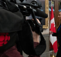 A CBC camera follows Minister of Canadian Heritage Pascale St-Onge as she leaves a microphone after speaking with media in the Foyer of the House of Commons about CBC funding, in Ottawa, Monday, Dec. 4, 2023. Adrian Wyld/The Canadian Press. 