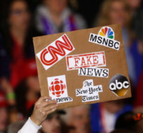 In this April 28, 2018 file photo, an audience member holds a 'fake news' sign during a President Donald Trump rally in Washington Township, Mich. Paul Sancya/AP Photo. 