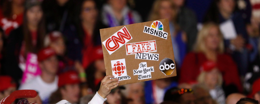 In this April 28, 2018 file photo, an audience member holds a 'fake news' sign during a President Donald Trump rally in Washington Township, Mich. Paul Sancya/AP Photo. 