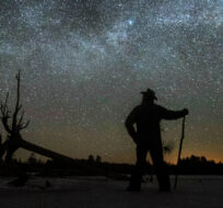 Stargazer Dave Cooke observes an unusual placement of the Milky Way, over a frozen fish sanctuary in central Ontario, north of Hwy 36 in Kawartha Lakes, Ont., on Sunday, March 21, 2021. For a few days twice during the year, the Milky Way Galaxy can be seen stretched laterally across the sky at, approximately 3.00 am. THE CANADIAN PRESS/Fred Thornhill