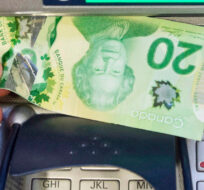 Money is removed from a bank machine in Montreal on May 30, 2016. Ryan Remiorz/The Canadian Press. 