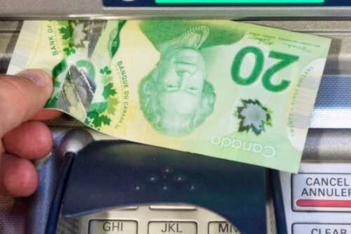 Money is removed from a bank machine in Montreal on May 30, 2016. Ryan Remiorz/The Canadian Press. 