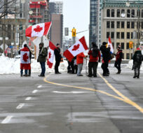 Demonstrators stand on Wellington Street as they mark the one year anniversary of the Freedom Convoy in Ottawa, on Saturday, Jan. 28, 2023. Justin Tang/The Canadian Press.