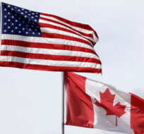 In this photo taken Sunday, May 17, 2020, U.S. and Canadian flags fly atop the Peace Arch at Peace Arch Historical State Park. Elaine Thompson/AP Photo. 