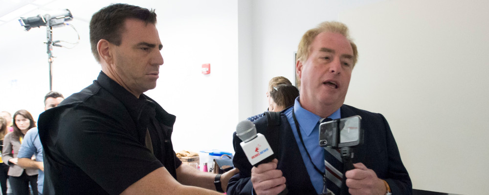 A member of the RCMP removes David Menzies, a reporter from Rebel Media, during a campaign stop for Conservative leader Andrew Scheer at the Abilities Centre in Whitby, Ont. Monday, September 30, 2019. Jonathan Hayward/The Canadian Press. 