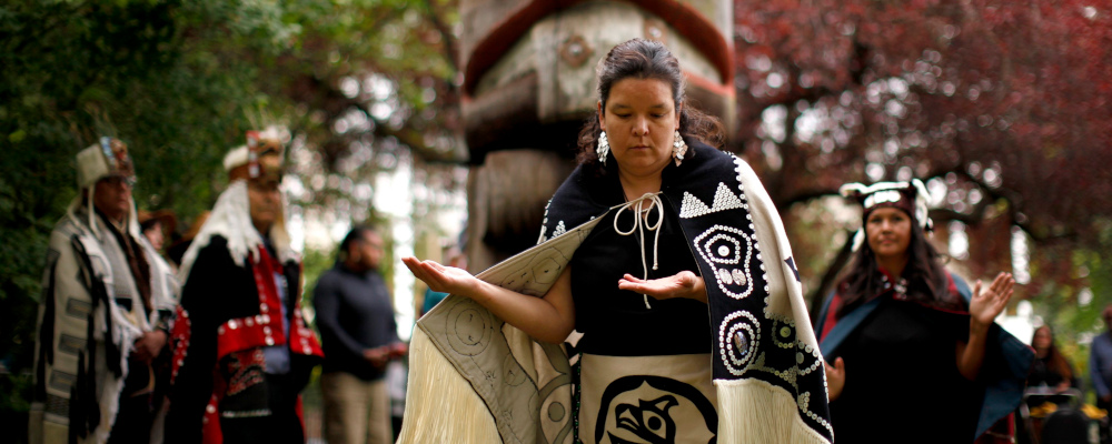 Krystal Hunt takes part in the Abyas song to help bless and cleanse the cedar mortuary pole replica during a commemorative ceremony on the grounds of the Royal B.C. Museum in Victoria, B.C., on Wednesday, June 5, 2019. Chad Hipolito/The Canadian Press. 