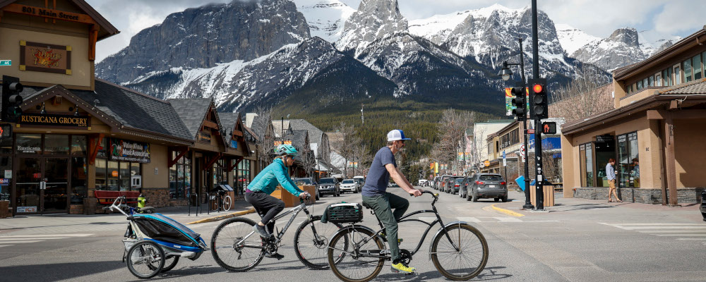 Cyclists ride through downtown Canmore, Alta., Monday, April 24, 2023. Jeff McIntosh/The Canadian Press. 