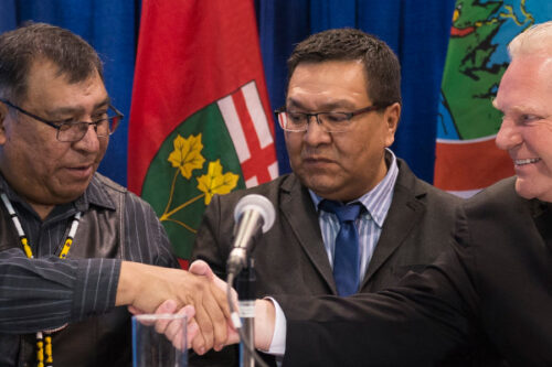 Ontario Premier Doug Ford shakes hands with Chief Cornelius, Wabasse Webequie First Nation, left, and Chief Bruce Achneepineskum, Marten Falls First Nation, centre, after signing a new deal in the ring of fire in Northern Ontario in Toronto on Monday, March 2, 2020. Nathan Denette/The Canadian Press. 
