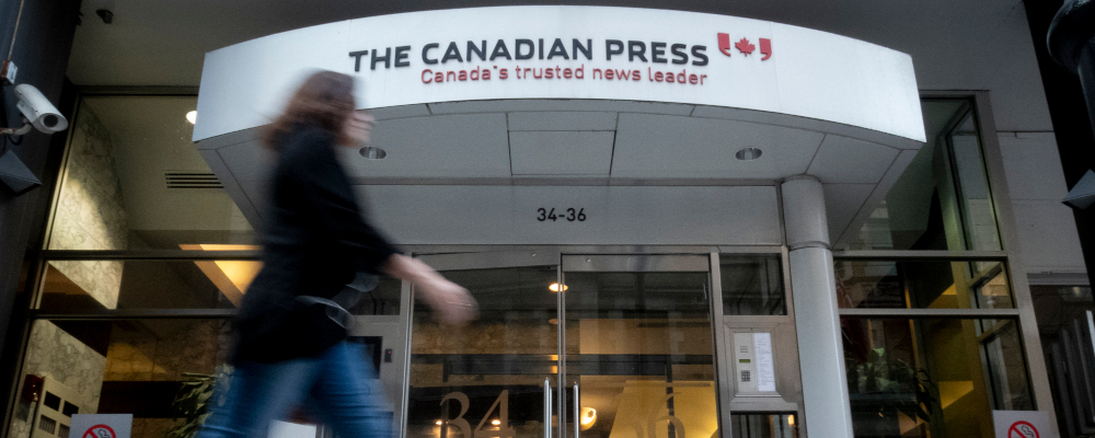 Pedestrians walk by The Canadian Press office building in Toronto on May 24, 2019. Graeme Roy/The Canadian Press. 