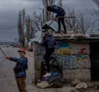 Ukrainian children play at an abandoned checkpoint in Kherson, southern Ukraine, Nov. 23, 2022. Bernat Armangue/AP Photo. 