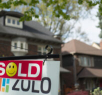 A sold sign is shown in front of west-end Toronto homes Sunday, May 14, 2017. Graeme Roy/The Canadian Press. 